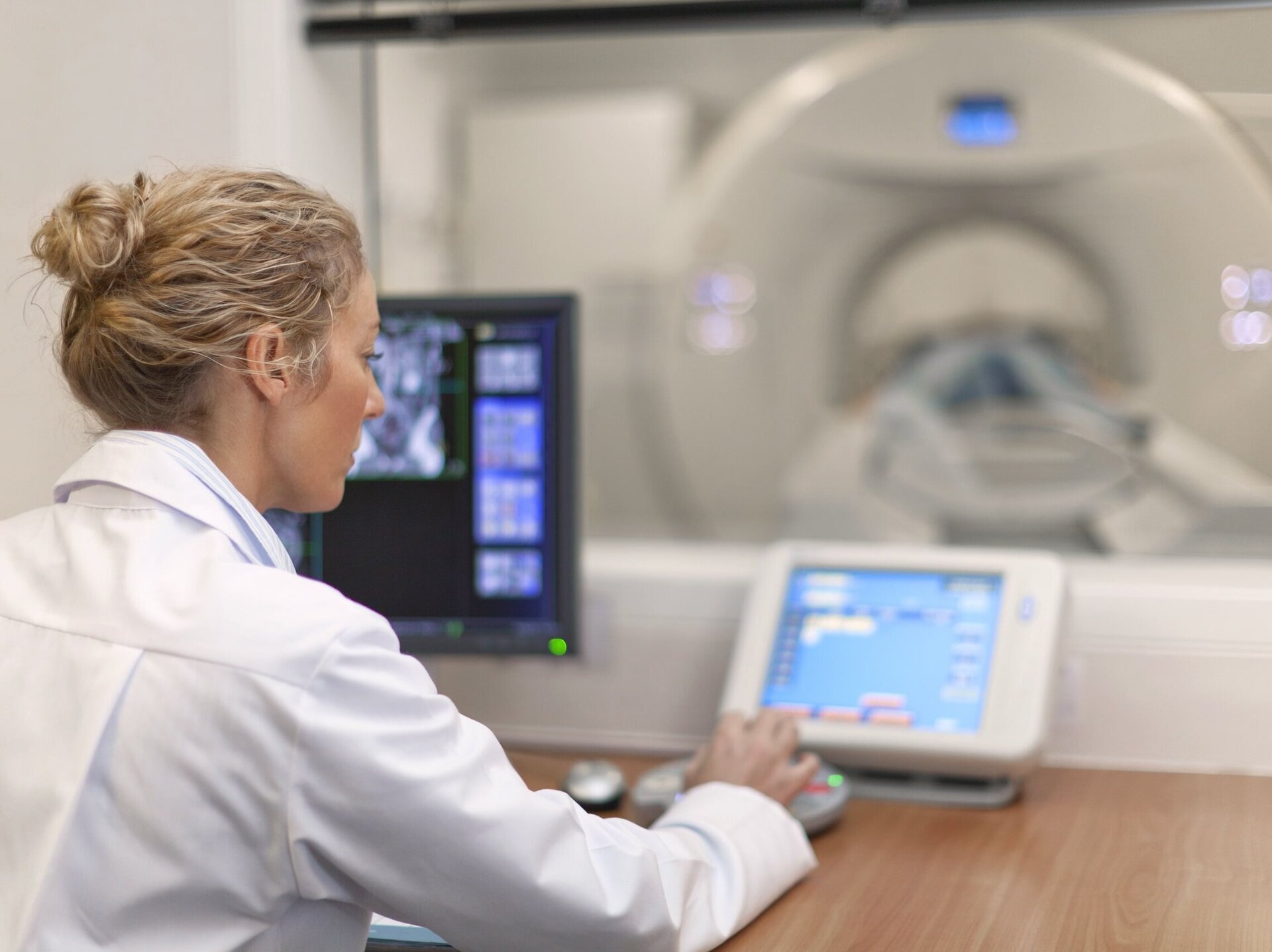 Ärztin stellt Bildschirm ein. Daneben ein Röntgenbild. Überwachung von Netzwerken und Systemen im Healthcare-Bereich. 